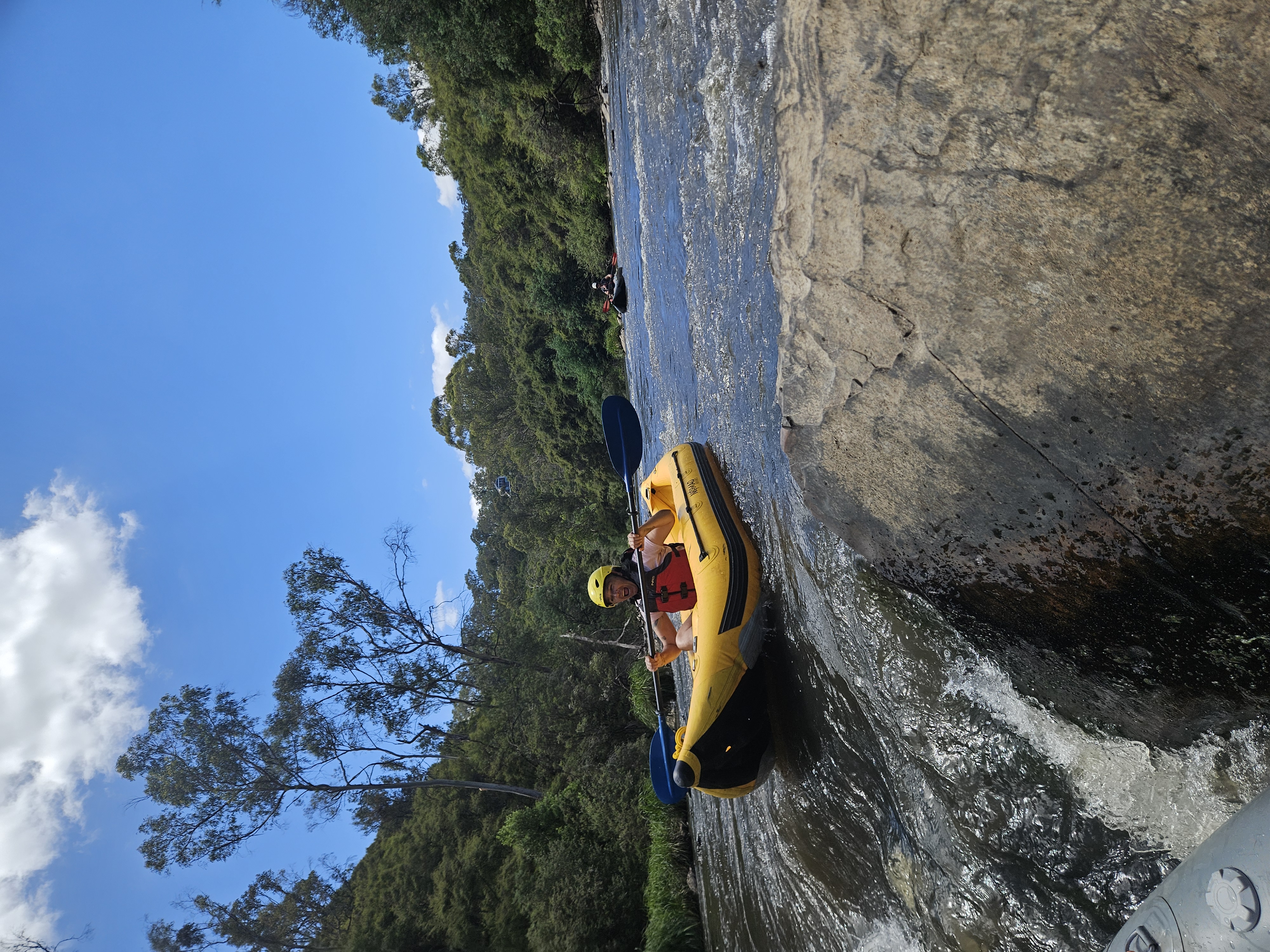 Paddler taking on a rapid in an inflatable kayak