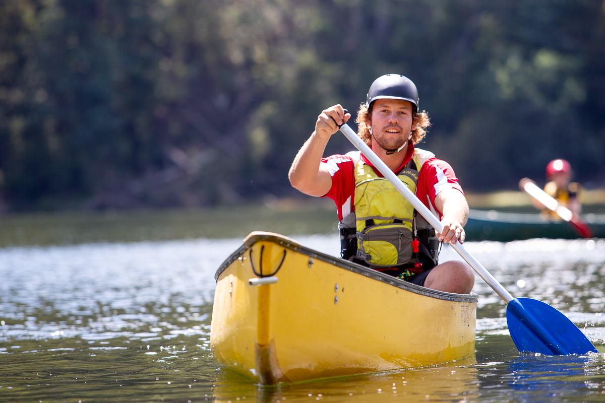 Paddler learning skills in a yellow open canoe