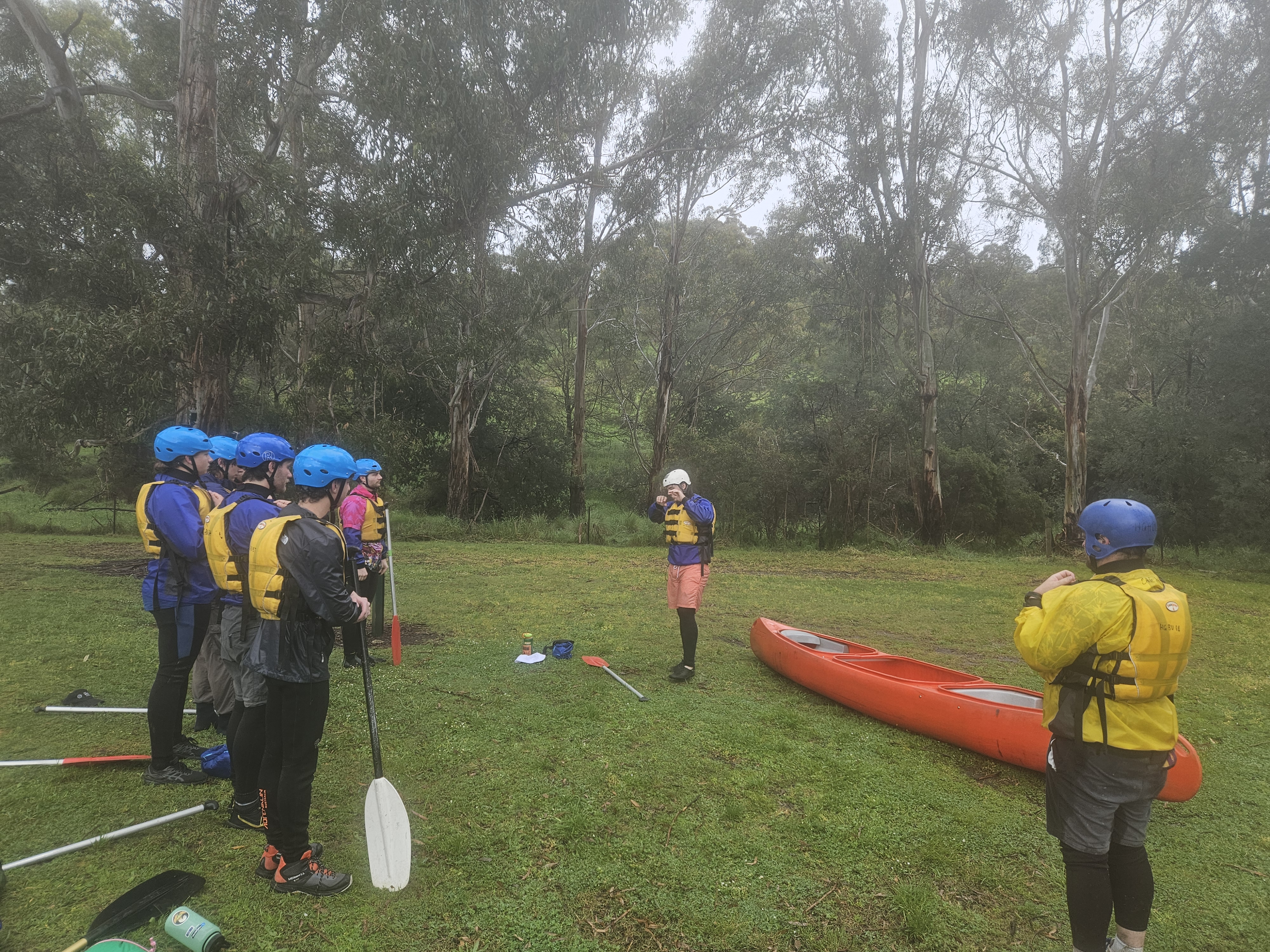 Instructor briefing paddlers beside the river