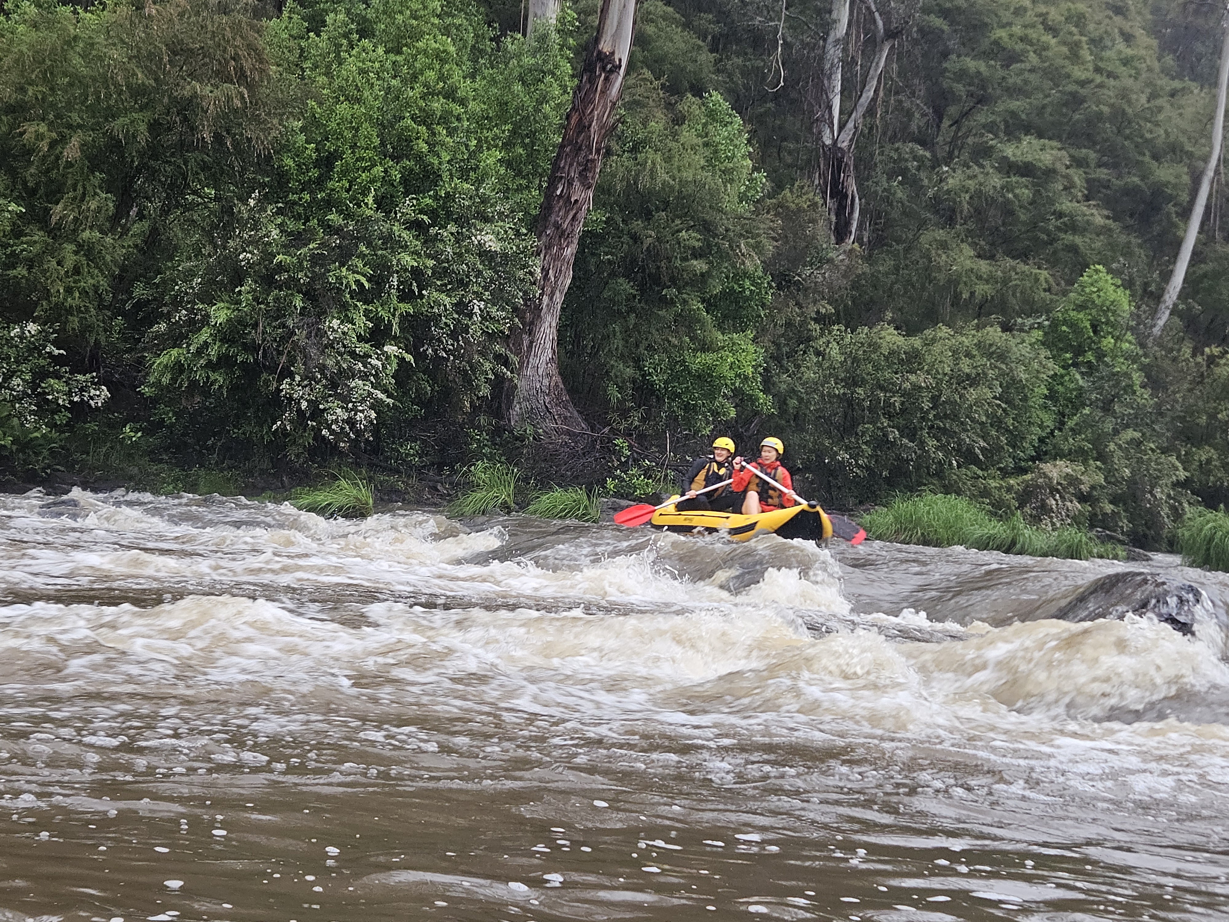Two women paddling through whitewater